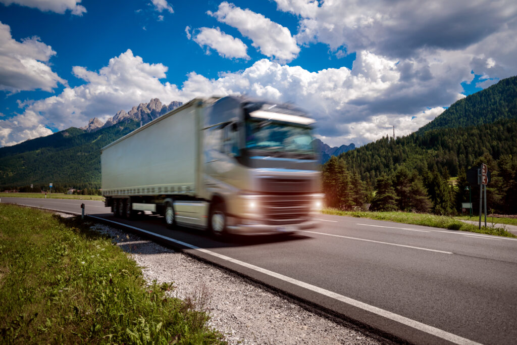 fuel truck rushes down the highway in the background the alps. truck car in motion blur.